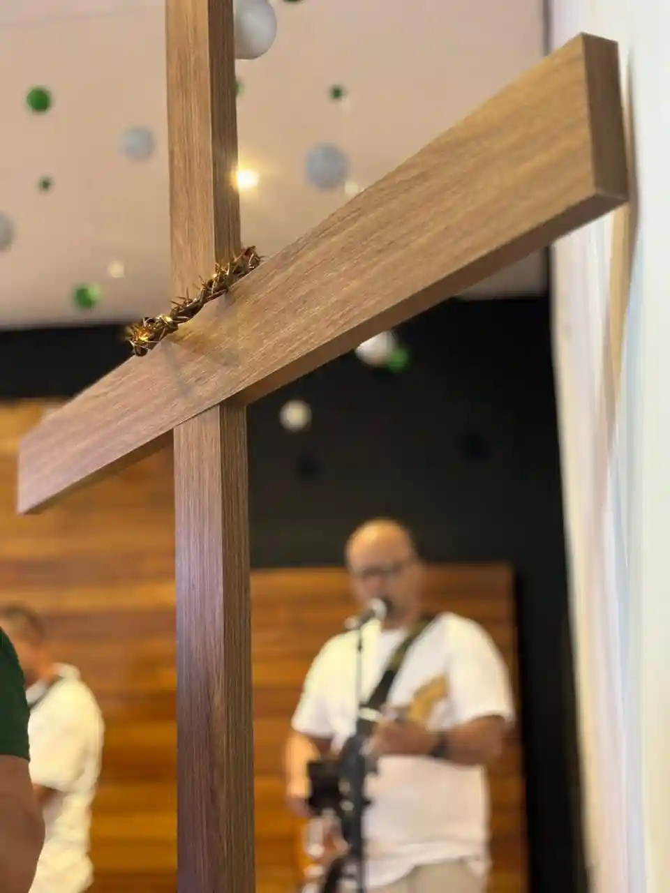 cruz e homem tocando violao