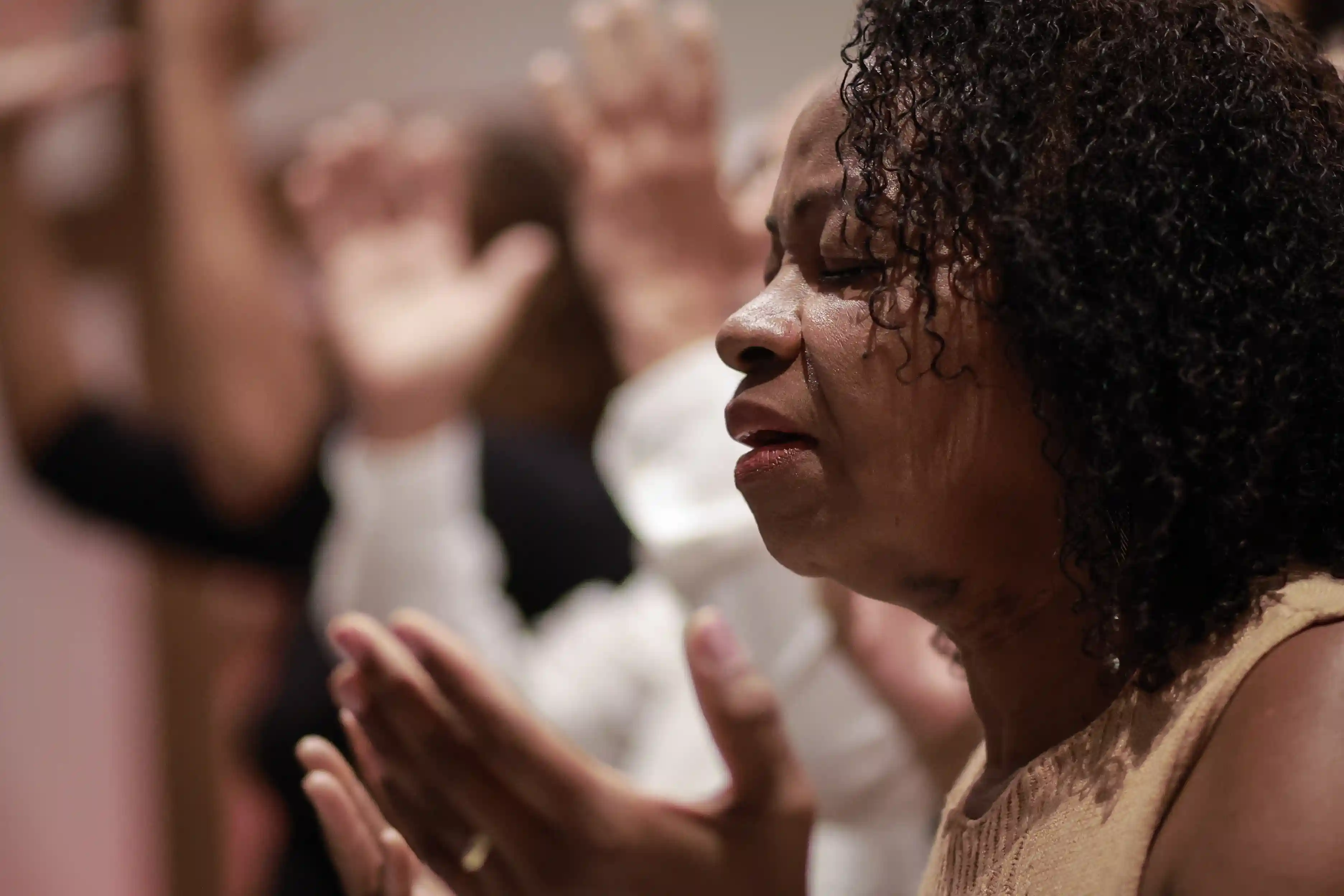 Mulher orando durante culto na IEJB